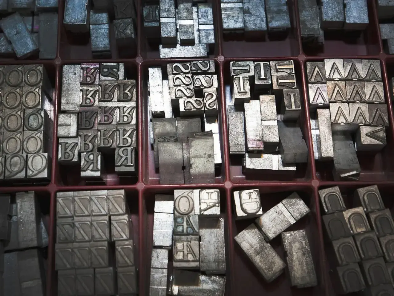 Metalowe czcionki do druku, w tym litery "K", "B", "R", "T", "A", "O", "6", "4", "2". Czy ołów przewodzi prąd? Te litery z pewnością mogłyby opowiedzieć historię.